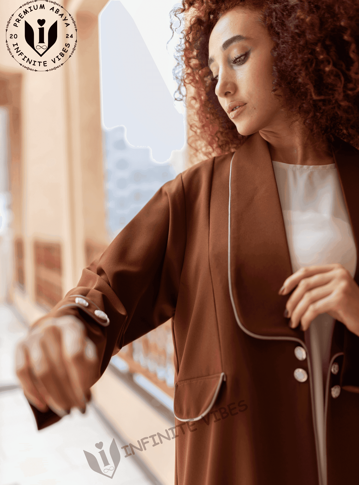 Woman wearing a brown designer abaya with white trim and button details, outdoor setting