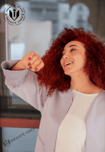 Smiling woman with curly red hair wearing a lavender designer abaya, modern modest fashion