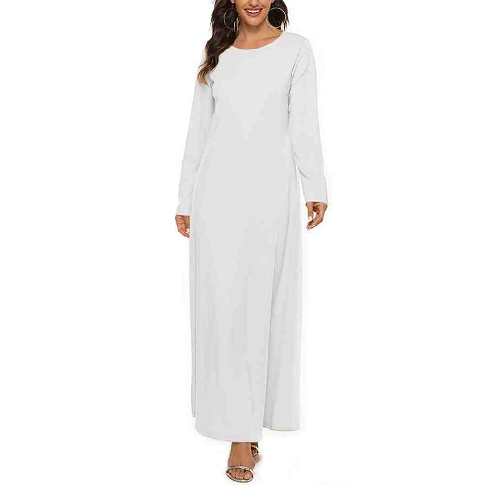 Woman wearing a plain white full-length abaya with long sleeves on a white background