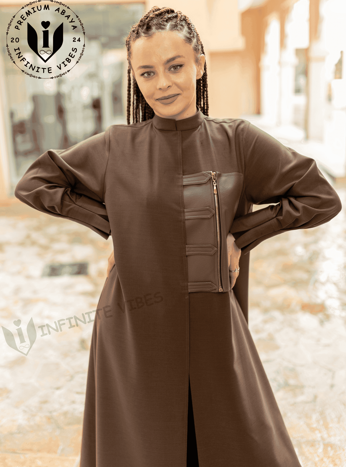 Woman wearing a brown designer abaya with front zipper detail, standing outdoors.