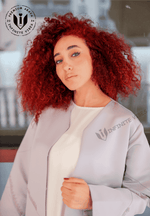 Woman with curly red hair wearing a light gray designer abaya, modern modest fashion