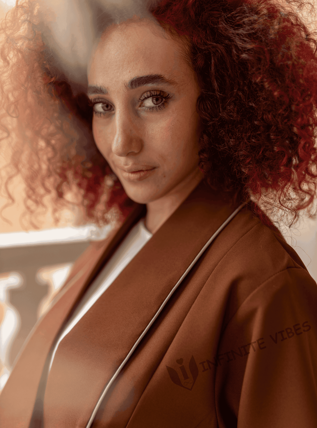 Woman with curly hair wearing a brown designer abaya, luxury modest fashion in UAE