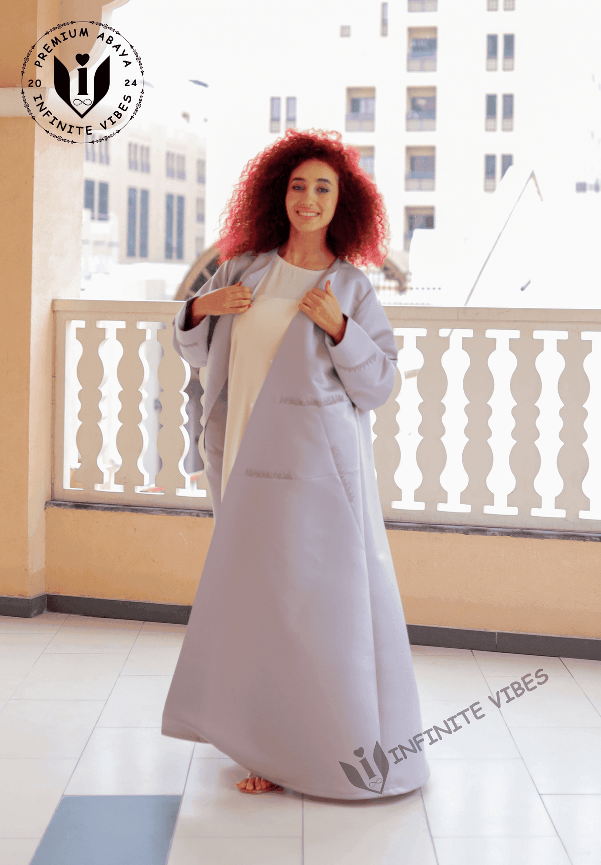 Woman wearing a light lavender designer abaya, standing on a balcony in Dubai