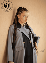 Woman in designer abaya with braids, wearing a light grey and black modest fashion outfit.