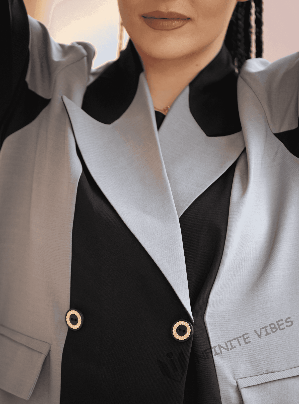 Close-up of woman wearing a designer two-tone abaya with bold lapels and gold buttons