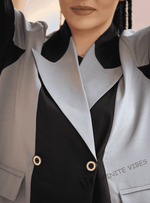 Close-up of woman wearing a designer two-tone abaya with bold lapels and gold buttons