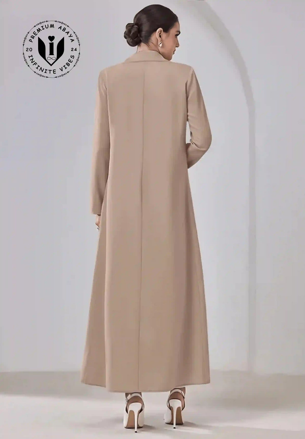 Back view of woman wearing beige designer abaya with long sleeves and white high heels