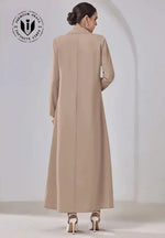 Back view of woman wearing beige designer abaya with long sleeves and white high heels