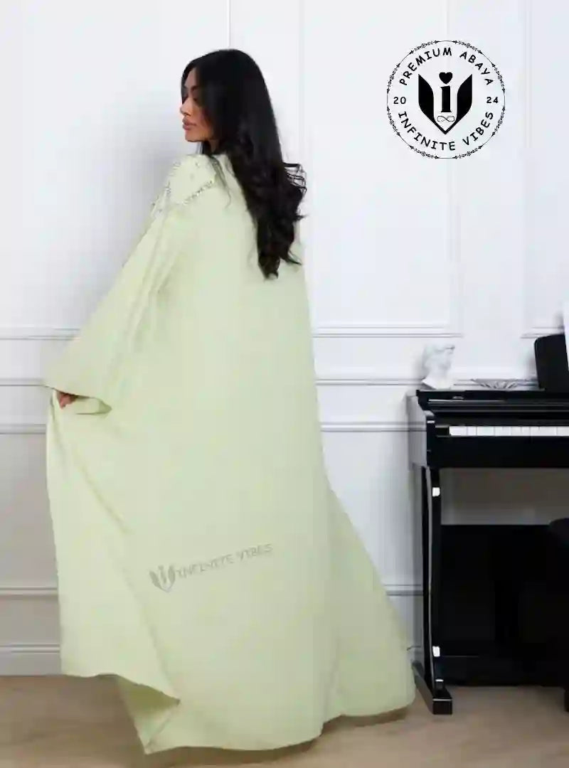 Woman in pistachio green chiffon abaya with crystal vine embroidery detail, modest fashion