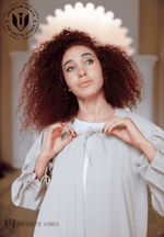 Woman wearing elegant dust storm color abaya with tie neckline, modest fashion style