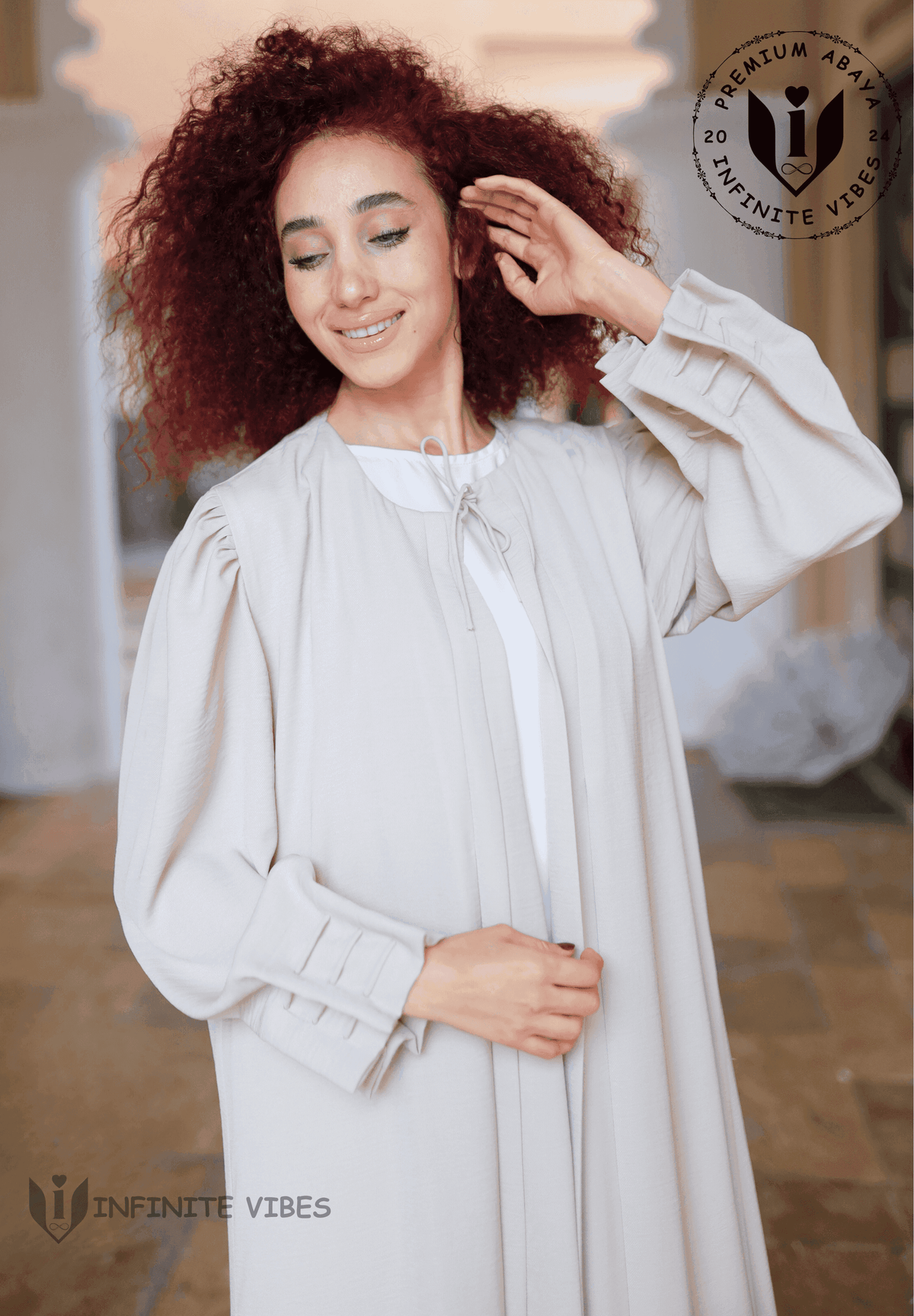 Woman wearing a light beige elegant abaya with pleated sleeves, standing outdoors.