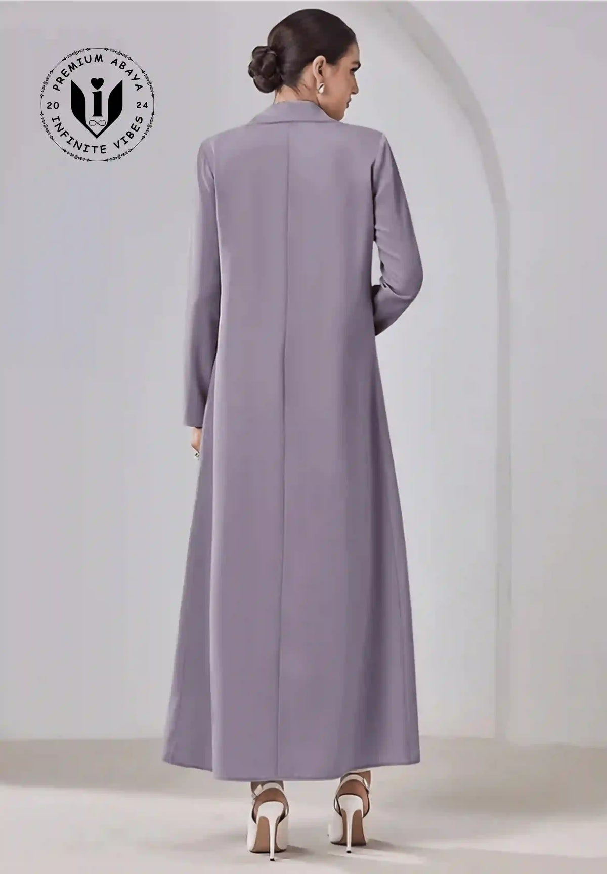 Elegant beige abaya with tailored design, long sleeves, and modest full length, viewed from back.