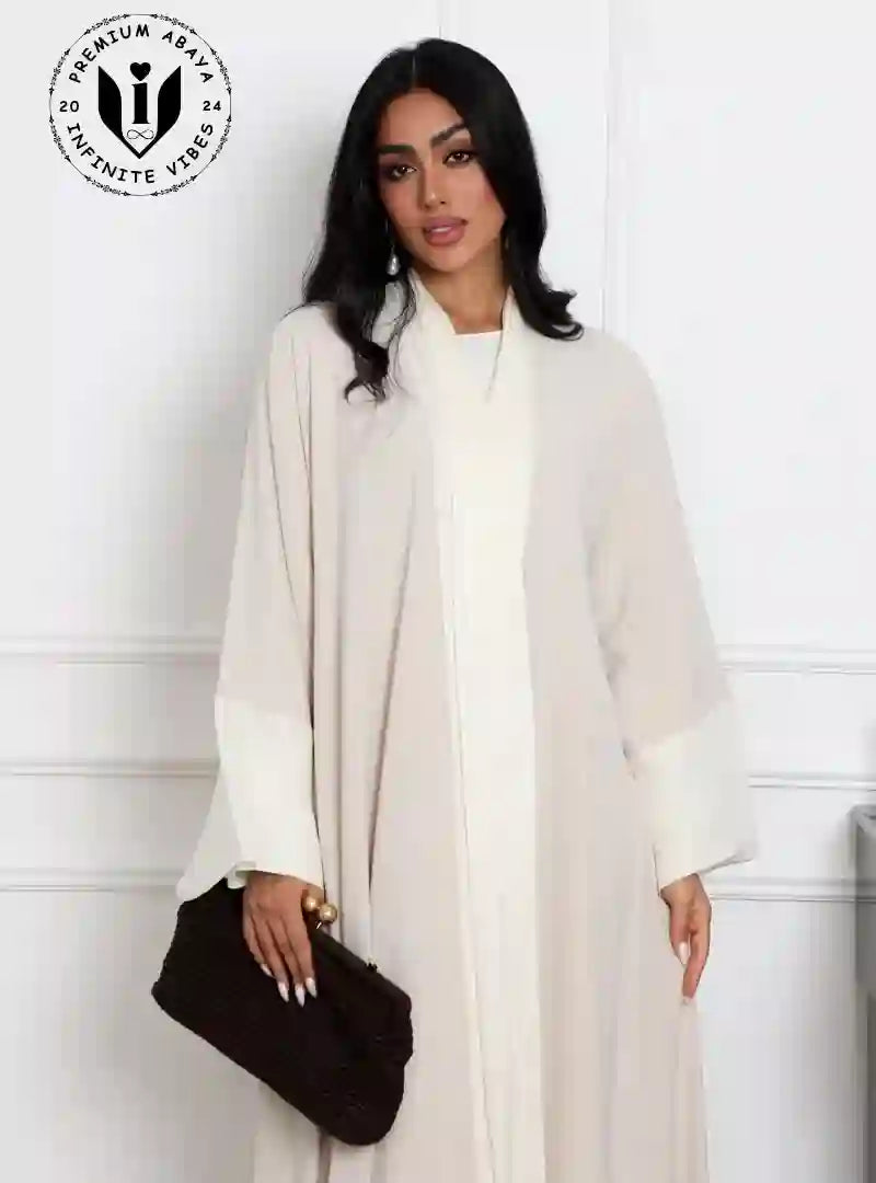 Elegant_beige_abaya_for_women_with_white_satin_details_and_black_clutch_