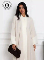 Elegant_beige_abaya_for_women_with_white_satin_details_and_black_clutch_