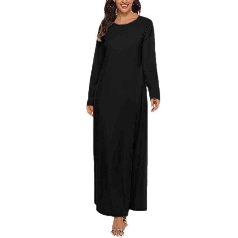 Woman wearing a plain black long-sleeve abaya, modest fashion, full-length dress