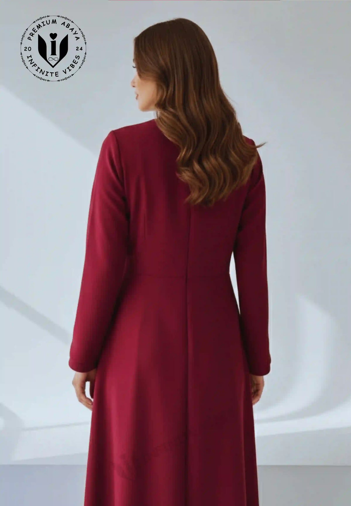 Back view of a woman in a full-length wine colored A-line abaya with long sleeves