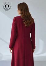 Back view of a woman in a full-length wine colored A-line abaya with long sleeves