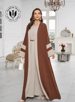 Woman wearing a brown and beige abaya in a stylish room.
