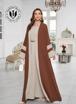 Woman wearing a brown and beige open abaya in an elegant, modern living room setting