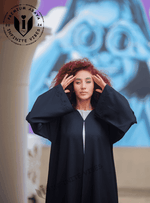 Woman wearing black handwork abaya with embroidery, standing outdoors, modern modest fashion