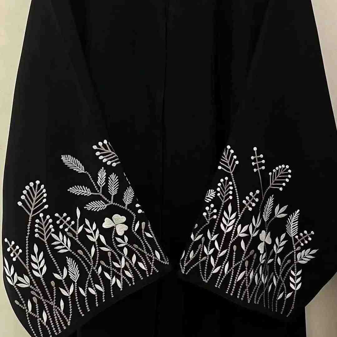 Black abaya with white floral embroidery on sleeves, modest fashion, designer abaya UAE
