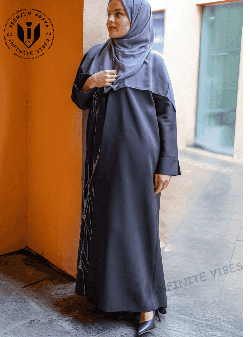 Woman in elegant black handwork abaya with embroidered details and grey hijab