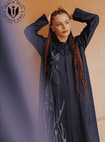 Woman wearing navy blue embroidered designer abaya with floral patterns, modest fashion.
