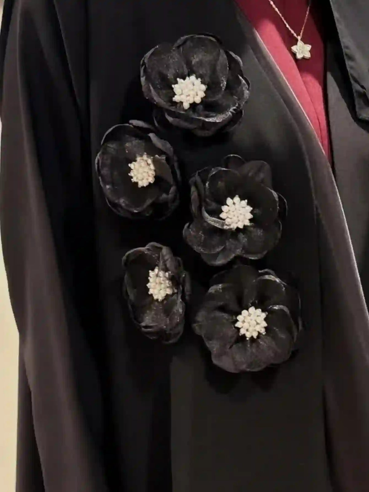 Black abaya with large 3D floral appliqués and pearl details, elegant modest fashion