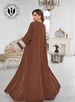 Woman wearing two-tone coffee brown and beige open abaya in elegant living room