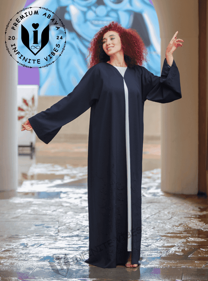 Woman wearing a luxury black abaya with wide sleeves and subtle embroidery, standing outdoors