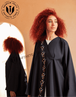 Woman wearing black embroidered abaya with floral beadwork, modern modest fashion