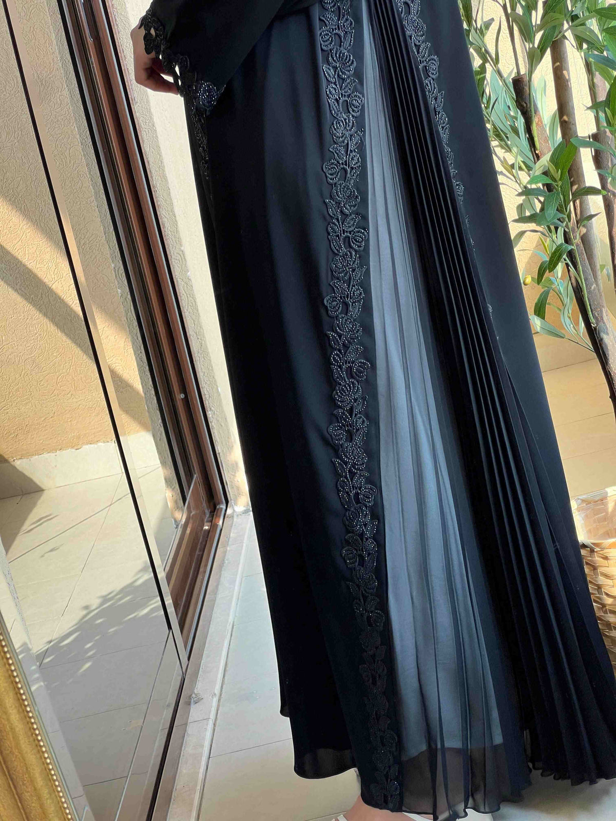 Black designer abaya with pleated panels and floral embroidery, modest fashion style
