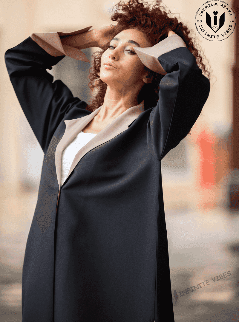 Woman modeling a black designer abaya with beige lapels, premium modest fashion UAE