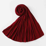 Folded red chiffon abaya hijab scarf on white background, modest fashion accessory