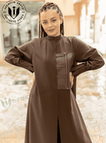 Woman wearing a brown designer abaya with front zipper detail, standing outdoors.