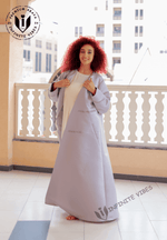 Woman wearing a light lavender designer abaya, standing on a balcony in Dubai