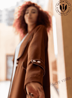 Woman wearing brown designer abaya with buttoned sleeve, outdoor Dubai setting