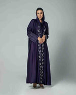 Woman wearing a navy blue embroidered abaya with modest long sleeves and hood