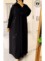 Black designer abaya with subtle leaf appliqué, loose fit, modest fashion style, indoors