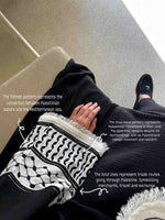 Woman wearing a black designer abaya with embroidered sleeve featuring Palestinian-inspired patterns and detailed symbolic motifs.