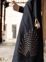 Black abaya with gold peacock feather-inspired embroidery, modest fashion UAE