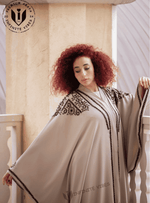 Woman wearing luxury butterfly abaya with black embroidery, modest fashion in UAE setting