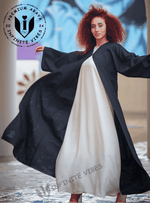 Woman wearing elegant black abaya over white dress, modern modest fashion in UAE