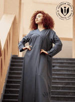 Woman wearing a premium gray abaya with button details on stairs, modest UAE fashion