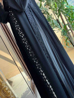 Black designer abaya with floral lace embroidery, modest fashion in natural light