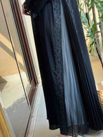 Black designer abaya with pleated panels and floral embroidery, modest fashion style
