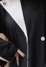 Close-up of a black abaya with white trim and buttons, showcasing modest fashion style