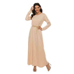 Woman wearing a beige modest abaya dress with gold belt, long sleeves and heels