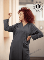 Woman wearing a modern grey abaya with button details, standing indoors in Dubai