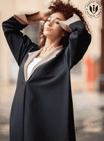 Woman modeling a black designer abaya with beige lapels, premium modest fashion UAE